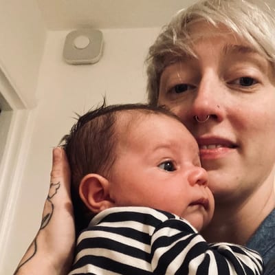 Bex Fédia holding her newborn son against her shoulder